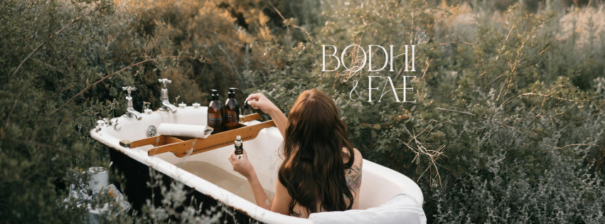 Woman relaxing in an outdoor hot tub surrounded by nature with 'Bodhi & Fae' branding.